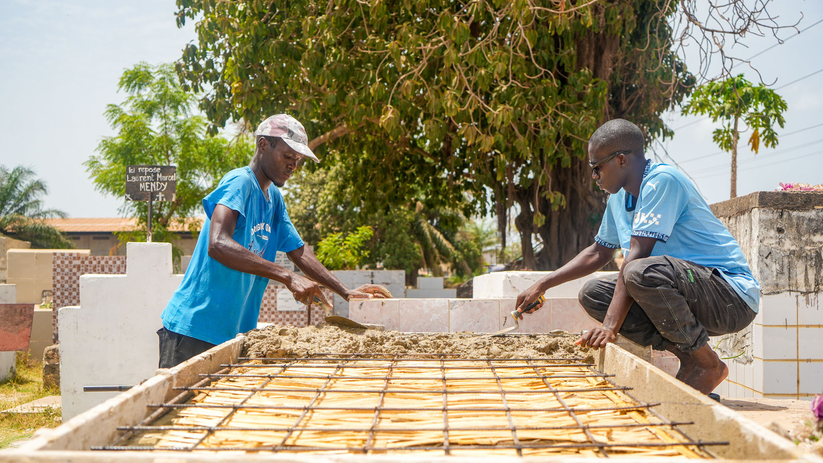 Maurer Denis Sané (l.) errichtet mit seinem Gehilfen Amadou ein Grab am 1. Juni 2026 auf dem Gemeinschaftsfriedhof in Ziguinchor (Senegal).
Bild: Frida Nsonde/KNA